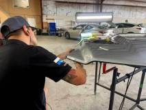 Superior Dent Repair PDR technician repairing dents on car hood.